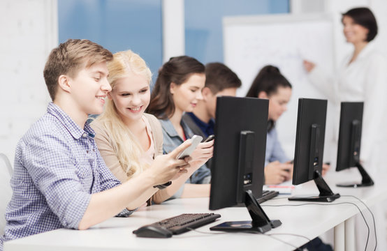 students with computer monitor and smartphones