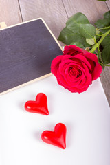 Schale mit roter Rose, Freitexttafel und Herzen
