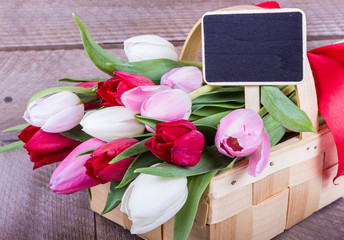 bunte Tulpen mit Tafel im Korb
