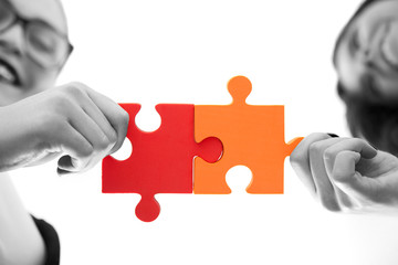 business women assembling jigsaw puzzle and