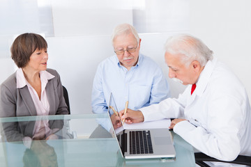 Doctor Writing Prescription For Senior Couple