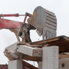 wreck excavator at work demolishing a building wall
