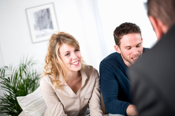 cheerful young couple with salesman at home