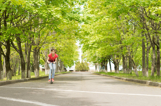 Young Teenage Girl Riding A Scooter