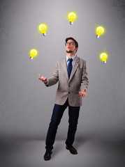 young man standing and juggling with light bulbs