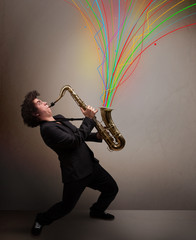 Attractive musician playing on saxophone while colorful abstract