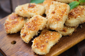 Rustic cutting board with sesame chicken nuggets, studio shot