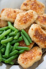 Fried chicken nuggets with green beans, close-up, vertical shot