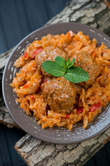 Close-up of meatballs, braised cabbage and mint, vertical shot