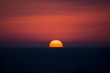 Fototapeta na wymiar Red disk of the sun. Sea sunset.