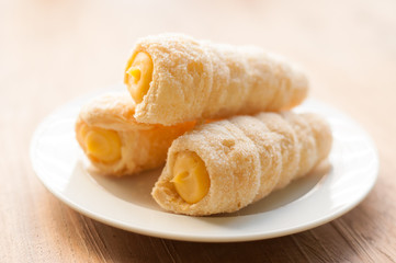 Cream-filled pastry roll on the wood board