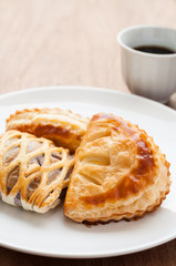 homemade fresh fruit pies on white dish with coffee