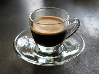 Small glass of espresso coffee on table
