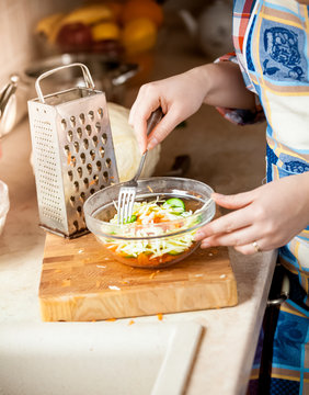 photo of housewife woman mixing salad with fork