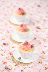 Lychee Rose Cupcake on a pink floral background.