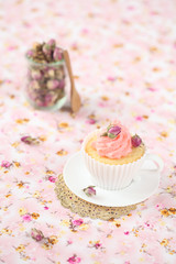 Lychee Rose Cupcake on a pink floral background.