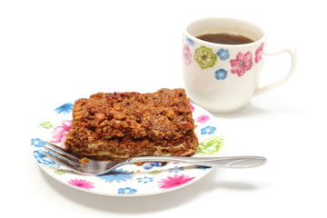 Delicious walnut cake on colorful plate and cup of coffee