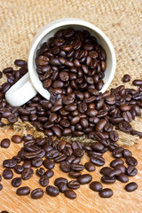 Coffee beans and cup on wood background