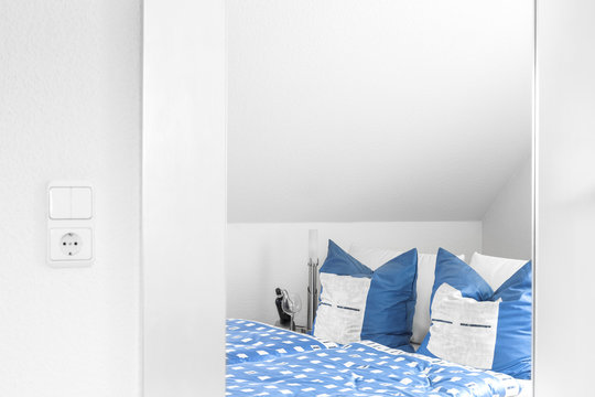 Schlafzimmer Bett mit blauen Kissen