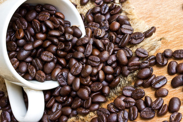 Coffee beans and cup on wood background