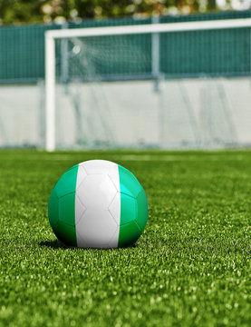 Soccer Ball with Nigeria Flag on the grass in stadium