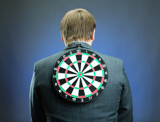 Businessman with darts board on his back