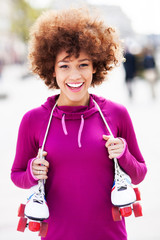 Afro-American woman holding roller-skates