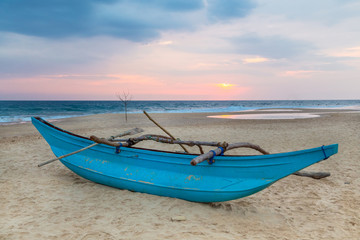 Fototapeta premium Traditional Sri Lankan fishing boat on empty sandy beach.