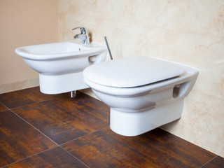 Hygiene. White porcelain bidet and toilet. Interior of bathroom.