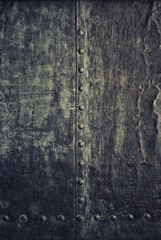 Grunge black metal plate with rivets screws background texture