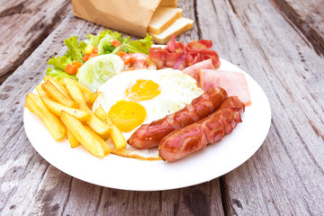 American  breakfast with fried eggs, bacon, sausages, beans, toa