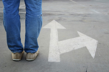 male with jeans and white direction arrow
