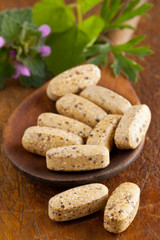 Herbal vitamin and supplement pills on spoon
