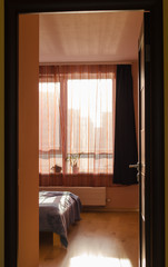 bed illuminated by sunlight window curtains