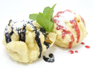 two eclairs decorated with mint sauce and a white background