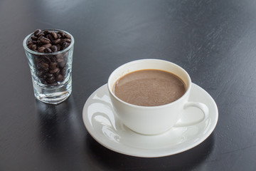 Coffee cup and beans in glass