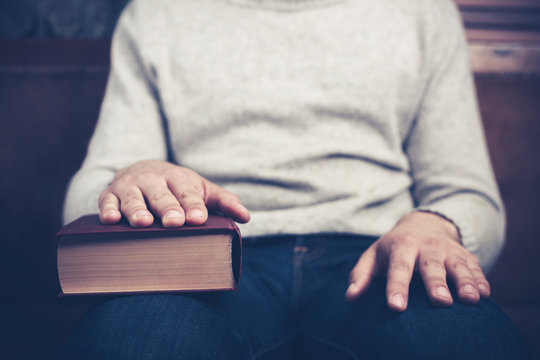Man sitting with his hand on a book