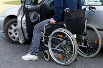 Fototapeta na wymiar Man in wheelchair next to car
