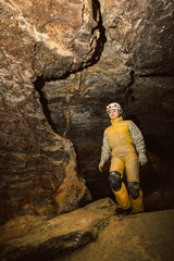Young female caver exploring the cave. Mlynky, Ukraine