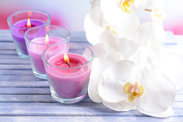 Beautiful colorful candles and  orchid flowers,