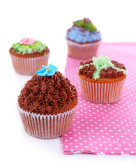 Tasty cupcakes with butter cream,on color napkin, isolated