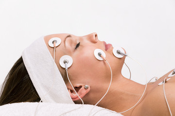 Portrait of a young woman lying  with electrodes on her face