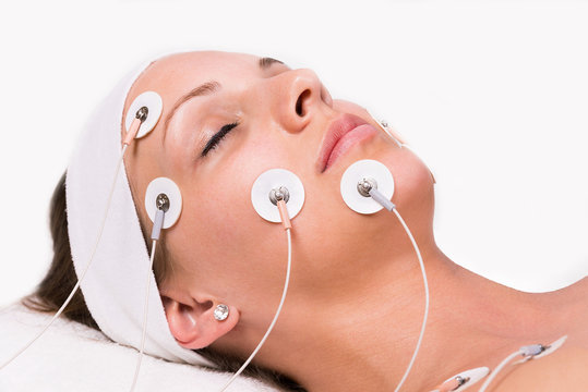 Portrait of a young woman lying  with electrodes on her face