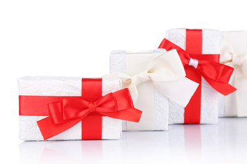 Beautiful gifts with red ribbons, isolated on white