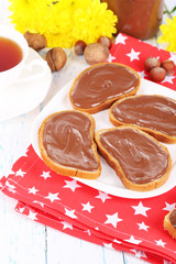 Bread with sweet chocolate hazelnut spread on plate on table
