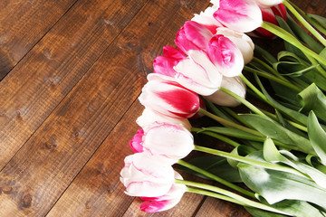 Beautiful tulips on color wooden background