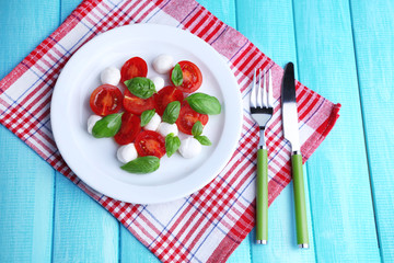 Caprese salad with mozarella cheese, tomatoes and basil
