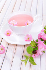 Beautiful fruit blossom with cup of tea on table close-up