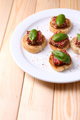 Tasty canapes with salami  and basil leaves,