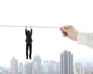 Holding rope and hanging in air with city building
